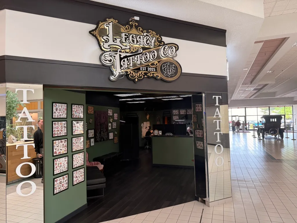 The Legacy Tattoo Company storefront inside Three Rivers Mall, with gold and black signage over the open entrance